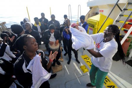 Migrants dance and sing to celebrate the birth of Miracle, a baby who was born on board the Aquarius, in the central Mediterranean Sea, May 26, 2018. REUTERS/Guglielmo Mangiapane