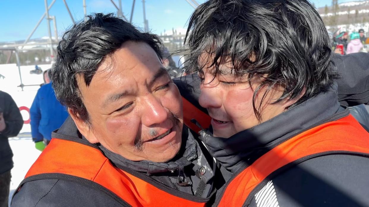 Randy Malleck of Sheshatshiu, left, and his son Sebastian crossed the finish line as winners of Cain's Quest on Thursday afternoon. (Darryl Dinn/CBC - image credit)