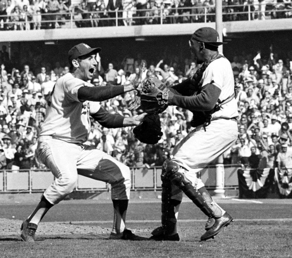 Dodgers pitcher Sandy Koufax, left, and catcher John Roseboro celebrate after sweeping the New York Yankees.