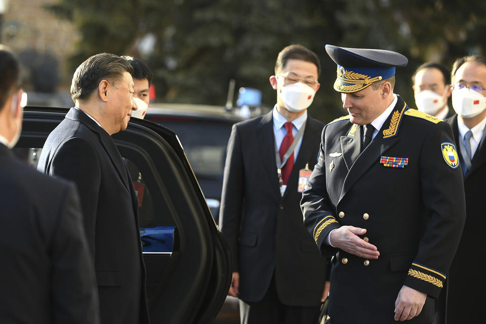 In this handout photo released by Russian Presidential Press Office, Chinese President Xi Jinping, left, is welcomed by Commandant of the Moscow Kremlin Sergei Udovenko as he arrives for the meeting with Russian President Vladimir Putin at the Kremlin in Moscow, Russia, Monday, March 20, 2023. (Russian Presidential Press Office via AP)