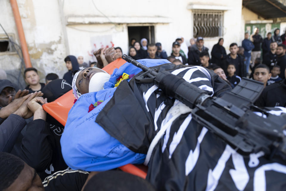 Mourners carry the body of Ahmad Faraj, 18 during his funeral in the West Bank refugee camp of Tulkarem, Friday, Jan. 19, 2024. The Israeli army withdrew early morning from the Tulkarem refugee camp after a 45 hours wide military operation in the refugee camp, the Israeli army said. Eight Palestinians were killed by the Israeli army during the Israeli army operation in the refugee camp, the Palestinian health ministry said. (AP Photo/Nasser Nasser)