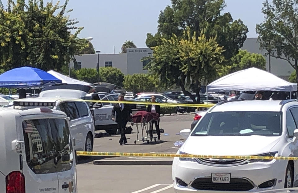 Orange County coroners remove a body of a stabbing victim from a parking lot from a parking lot at California State University, Fullerton on Monday, Aug. 19, 2019. An employee of the university was killed in a stabbing in a campus parking lot Monday in what police called a targeted attack, though they were not sure of a motive. The victim was in his late 50s and worked in international student admissions at the sprawling campus in Orange County, police Lt. Jon Radus said. He was not immediately identified by authorities. (AP Photo/Amy Taxin)