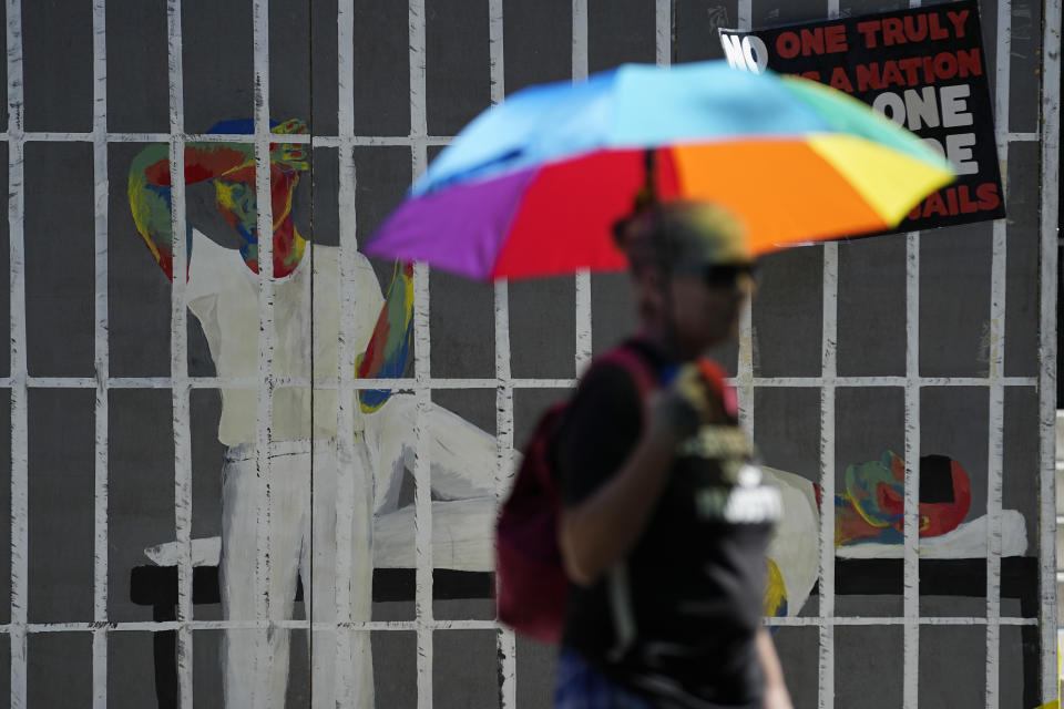 An advocate for cooling Texas prisons walks past a make-shift cell during a rally on the steps of the Texas Capitol, Tuesday, July 18, 2023, in Austin, Texas. The group is calling for an emergency special session to address the deadly heat effecting inmates. (AP Photo/Eric Gay)