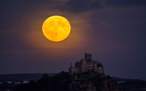 The full Harvest moon rises over St Michael's Mount in Cornwall - Credit: Simon Maycock / Alamy Live News