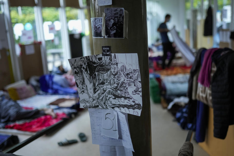 Photos, drawings and a black sticker that reads in Flemish: "Nobody is illegal" are fixed in a room occupied by migrants at the VUB Dutch-speaking university in Brussels, Tuesday, June 29, 2021. More than two hundreds of migrants without official papers and who have been occupying a church and two buildings of two Brussels universities since last February, began a hunger strike on 23 May to draw the attention of Brussels authorities to their plight. (AP Photo/Francisco Seco)