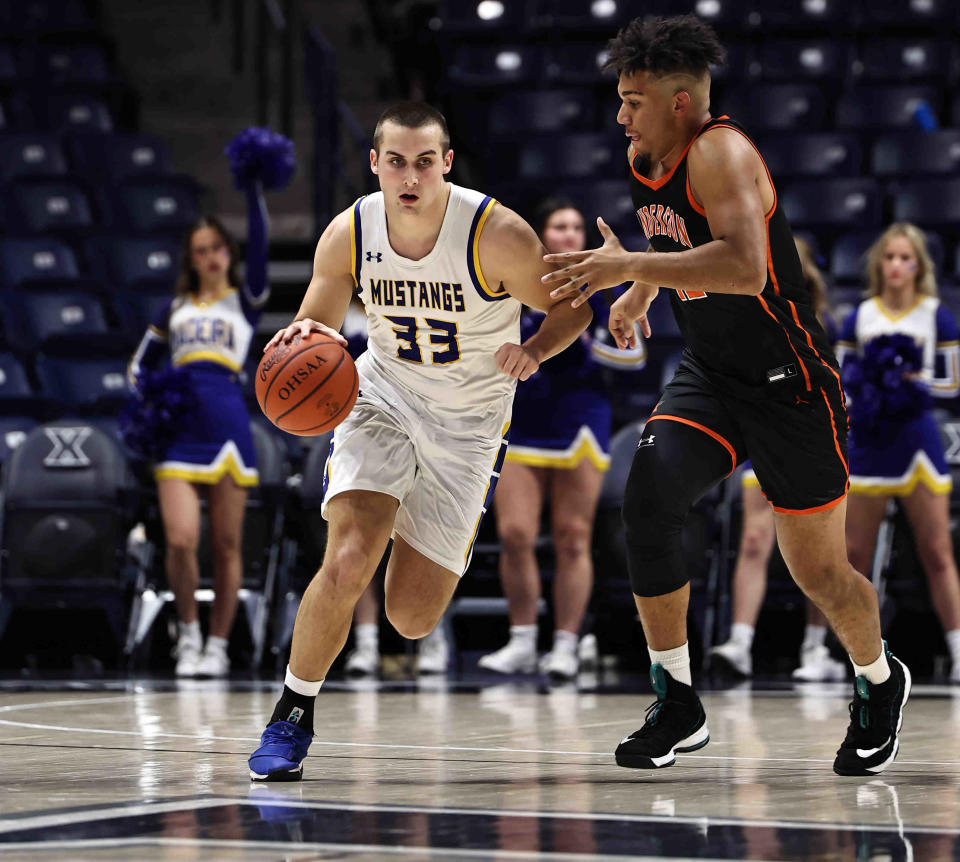 Madeira forward Conner Cravaack (33) brings the ball up the court against Anderson's Chandler Starks (42). Madeira is the top seed in Division III.