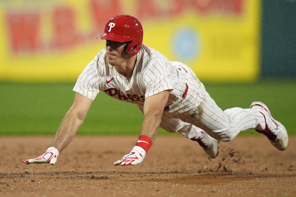 Philadelphia Phillies' J.T. Realmuto dives to third base after hitting a triple against San Francisco Giants pitcher Mitch White during the second inning of a baseball game, Saturday, May 4, 2024, in Philadelphia. (AP Photo/Matt Slocum)