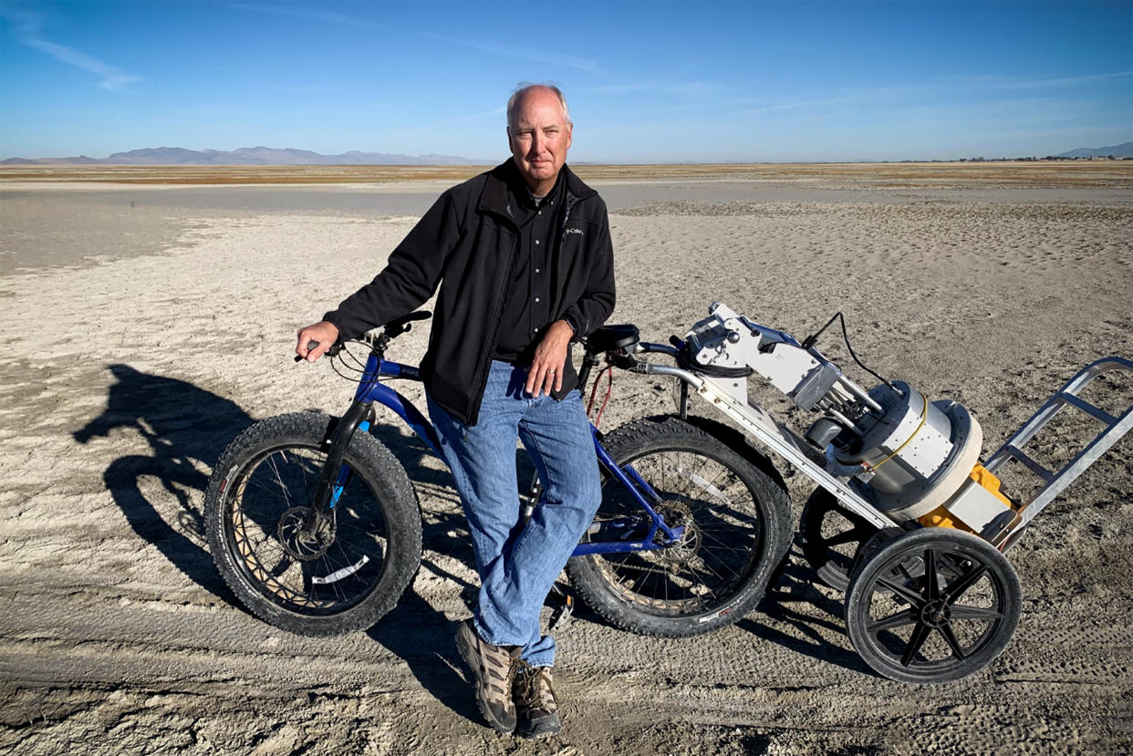 Dust researcher Kevin Perry poses with his fat bike and a PI-SWERL machine, which can measure wind erosion and dust emission. (Evan Bush / NBC News)