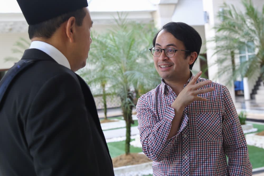 Mohd Ezra Mohd Zaid speaks with his lawyer Zulkifli Che Yong at the Petaling Jaya District Syariah Subordination Court October 17, 2019. — Picture by Yusof Mat Isa