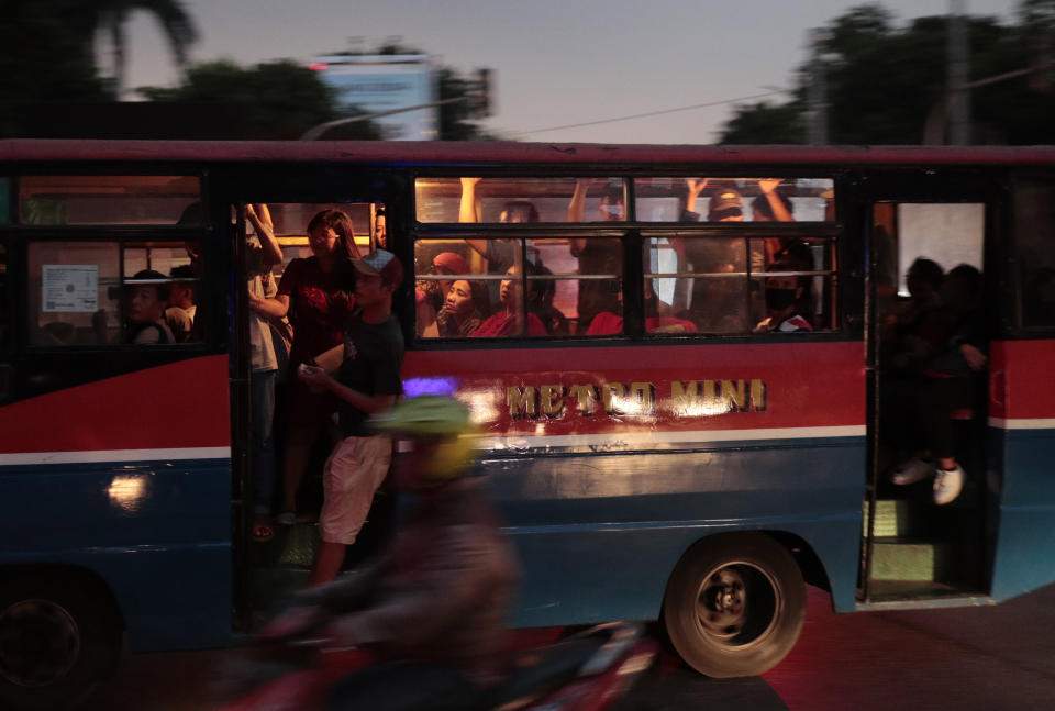 People ride on a public bus during a power outage in Jakarta, Indonesia, Sunday, Aug. 4, 2019. Indonesia's sprawling capital and other parts of Java island have been hit by a massive power outage affecting millions of people. (AP Photo/Dita Alangkara)