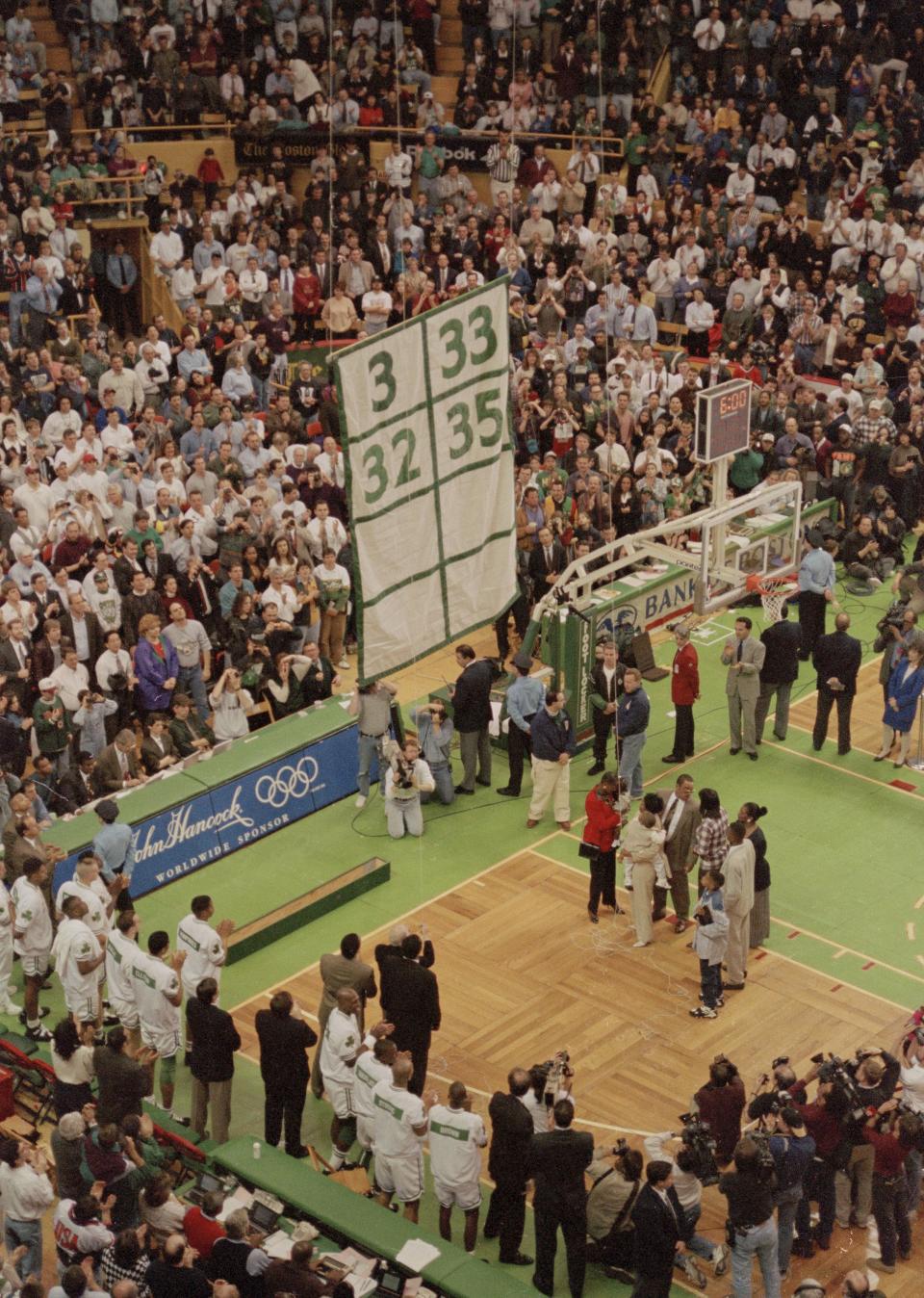 A banner bearing Reggie Lewis’ No. 35 is hoisted up to the rafters by his wife Donna Harris-Lewis during a halftime ceremony at the Boston Garden, March 22, 1995. | Charles Krupa, Associated Press