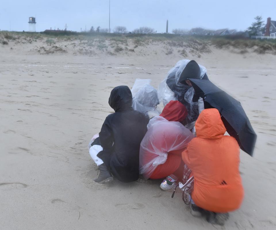 CHATHAM  05/03/22 The production crew huddles under umbrellas to watch a video monitor in a wind driven rain at Lighthouse Beach in Chatham during the filming of a movie short called Clam Shack Blues. Steve Heaslip/Cape Cod Times 