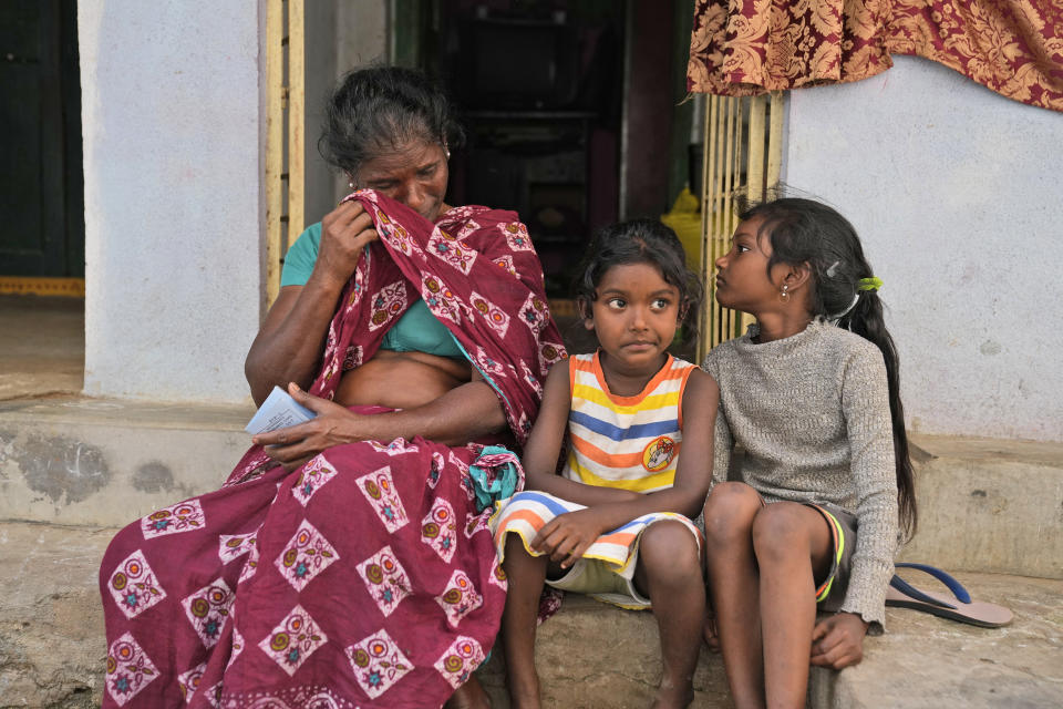 Erugala Baby, 51, widowed and destitute, wipes tears from her eyes during an interview at her residence in Bhogapuram, Kakinada district, Andhra Pradesh, India, Saturday, Feb. 10, 2024. She says she works in brutal conditions, peeling, cutting and grading shrimp in a factory for less than $4 a day, which is $2 less than minimum wage. (AP Photo/Mahesh Kumar A.)