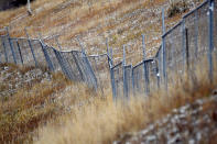 A chain-link fence marks the boundary of a contentious plot of land in Vail, Colo., on Oct. 25, 2022. For more than six years, Vail Resorts has been trying to build apartments for about 160 of its workers on the property called Booth Heights. Opponents say the project would encroach on the bighorn sheep herd that frequents the area. (AP Photo/Thomas Peipert)