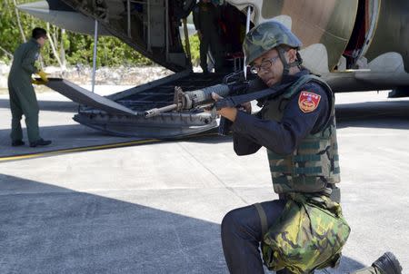 A Taiwanese coast guard secures a C-130 military transport plane on the tarmac, in Itu Aba, which the Taiwanese call Taiping, at the South China Sea, March 23, 2016. REUTERS/Fabian Hamacher