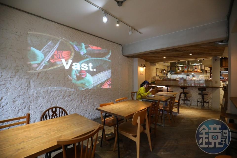 店內座位區牆上用投影機撥放著關於「VAST Cali Eatery」的品牌理念影片。