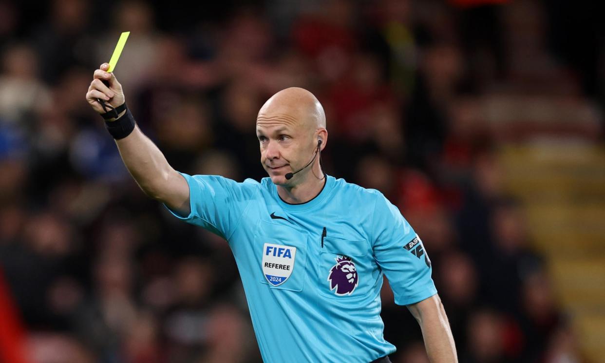 <span>Anthony Taylor shows one of 14 yellow cards he issued in Chelsea’s 1-0 win at Bournemouth.</span><span>Photograph: Catherine Ivill/AMA/Getty Images</span>