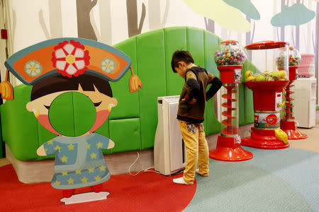 A boy looks at an air purifier at the indoor playground 'Adventure Zone' at Kerry Hotel in Beijing February 12, 2015. REUTERS/Kim Kyung-Hoon