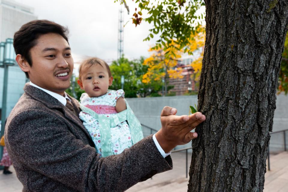 Ricko Putra and his daughter Kikanaya put a katydid he rescued from the ground on a tree before the Sunday morning session of the 193rd Semiannual General Conference of The Church of Jesus Christ of Latter-day Saints at the Conference Center in Salt Lake City on Sunday, Oct. 1, 2023. | Megan Nielsen, Deseret News