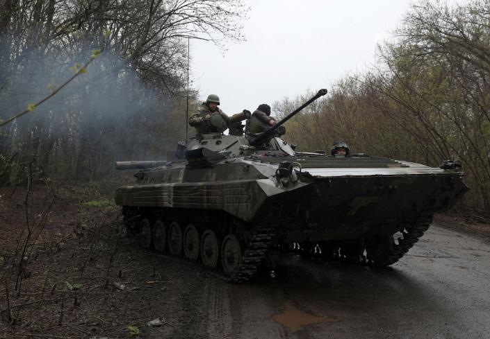 Ukrainian soldiers stand on an armored personnel carrier (APC), near the front line with Russian troops, in the Izyum district of the Kharkiv region on April 18, 2022.