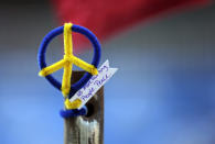 A peace symbol bearing the words of 2013 Boston Marathon bombing victim Martin, "No more hurting people. Peace," is affixed to a pole near the finish line of the 118th Boston Marathon Monday, April 21, 2014 in Boston. (AP Photo/Charles Krupa)