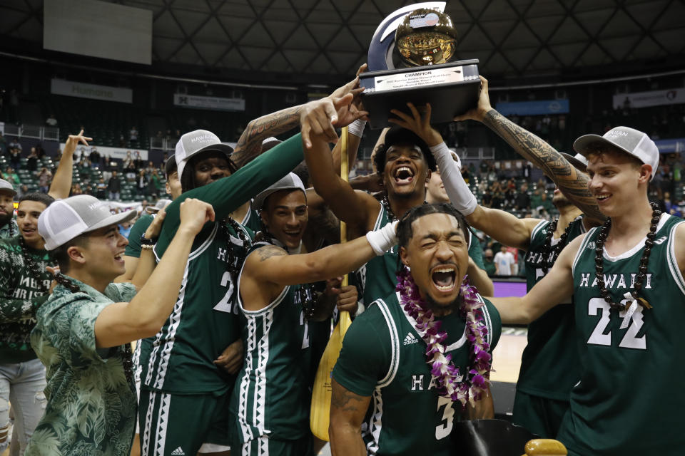 Hawaii hoists the winning trophy after defeating SMU to win the Diamond Head Classic NCAA college basketball game, Sunday, Dec. 25, 2022, in Honolulu. Hawaii defeated SMU 58-57. (AP Photo/Marco Garcia)