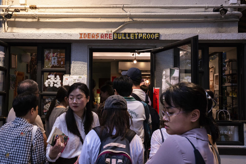 FILE - A sign reading 'IDEAS ARE BULLETPROOF' is seen as visitors browse books on the last day of business of independent bookshop 'Mount Zero' in Hong Kong, Sunday, March 31, 2024. Two weeks after Hong Kong introduced a new national security law, life in the city appears unchanged. A 2020 law drew thousands of protesters to the streets when it was enacted. Now, that's seen as too risky. (AP Photo/Louise Delmotte, File)