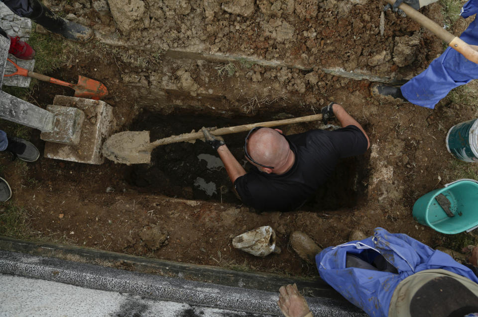 A man works to exhume the tomb of Julius H. Kroehl from Amador Cemetery in the Chorrillo neighborhood of Panama City, Thursday, Oct. 11, 2018. The remains of Kroehl, a German-American who was a pioneer on the design of the first submarine to submerge successfully at depth, are being moved to Corozal Cemetery where American veterans are buried. (AP Photo/Arnulfo Franco)