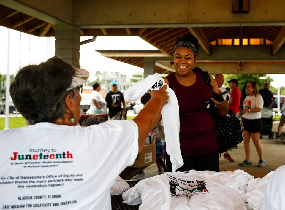 Volunteers distribute T-shirts ahead of the Journey to Juneteenth Freedom walk at Depot Park on Saturday, June 19, 2021. This year's walk will be held at  [Chasity Maynard/Special to The Sun]