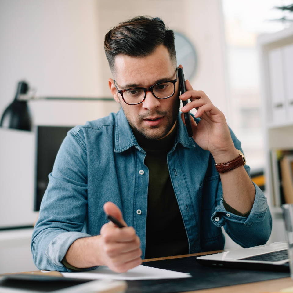 Businessman in office. Handsome man talking on phone at work.