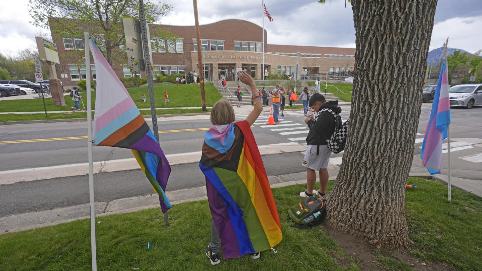 Bonneville Elementary School 5th grader Graham Beeton, waves to fellow students during a block party supporting trans and non binary students and staff Monday, April 29, 2024, in Salt Lake City. Utah will become the latest state to implement restrictions for transgender people using school bathrooms and locker rooms in public schools and government-owned buildings when key components of a law passed by the Republican controlled Legislature take effect May 1. (AP Photo/Rick Bowmer)