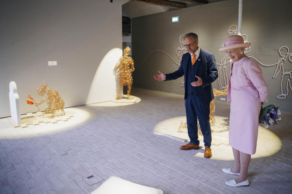 CORRECTS SPELLING OF NAME The Danish Queen Margrethe and museum director Claus Kjeld Jensen walk during the inauguration of the new museum Flugt, in Oksboel, Denmark, Saturday, June 25, 2022. Flugt — Refugee Museum of Denmark was created on the site of a camp in Oksboel, a town in southwestern Denmark, that housed up to 100,000 refugees from Germany in the postwar years. Flugt — which means escape in Danish — also tells the story of immigrants from Iran, Lebanon, Hungary, Vietnam and elsewhere who fled their homelands and found shelter in the Scandinavian country. (Bo Amstrup/Ritzau Scanpix via AP)