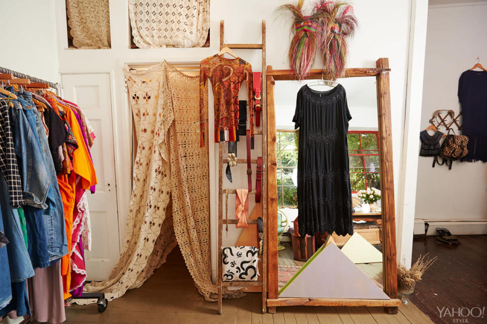 A crocheted tapestry hangs, leading to a dressing room.