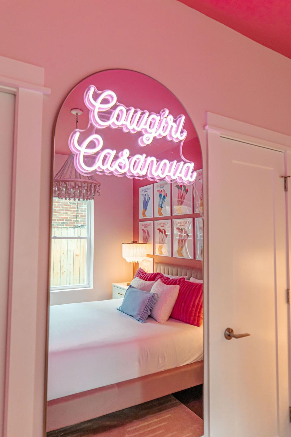 A mirror with a neon sign that says "Cowgirl Casanova."