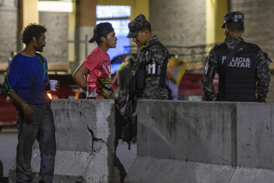 Military police patrol the main bus station in San Pedro Sula, Honduras, on Nov. 28, 2019. Until a few months ago, the bus station was crowded with migrants heading north towards the U.S. Now many buses leave with just a few passengers. (AP Photo/Moises Castillo)