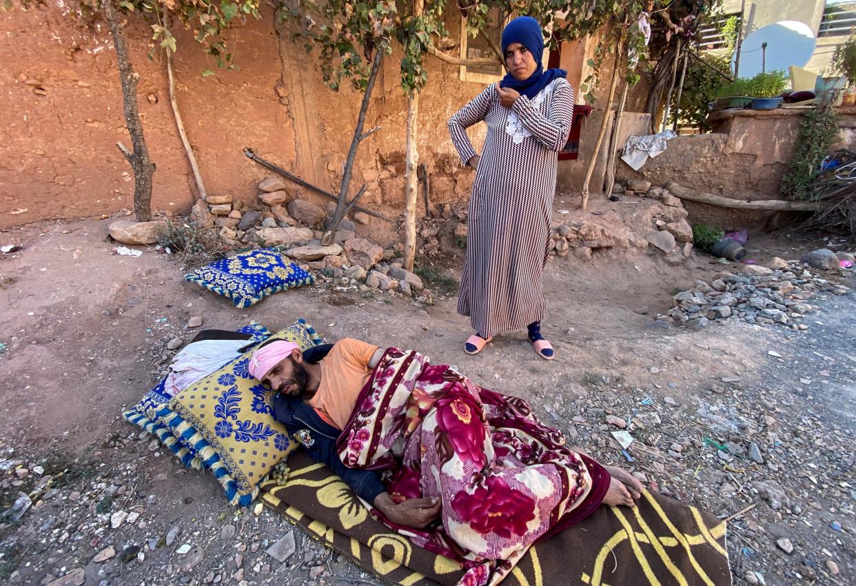 Abdellatif Ait Bella, who was injured in the earthquake that destroyed his home, lies on the ground next to his wife Saida Bodchich, as they prepare to spend a second night in the open air, in the village of Tansghart in the Asni area (Reuters)