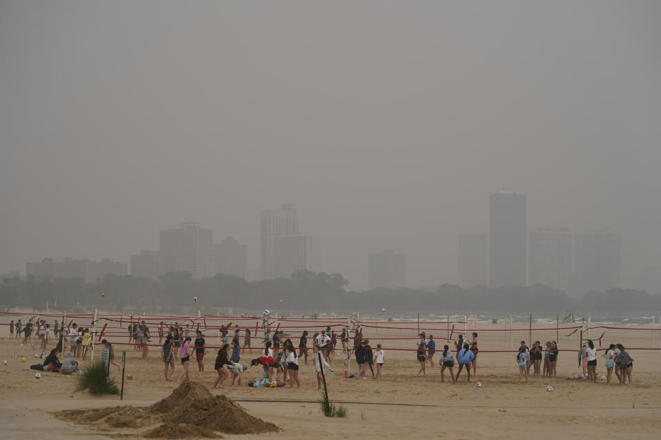 Children participate in a summer camp on Montrose Beach as buildings behind the shore are blanketed in haze from Canadian wildfires Tuesday, June 27, 2023, in Chicago. (AP Photo/Kiichiro Sato)