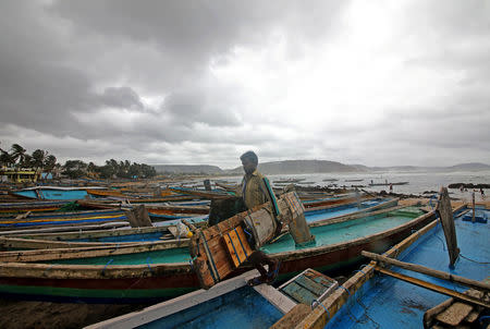A fisherman carries his tools as he leaves for a safer place after tying his boats along the shore ahead of cyclone Fani in Peda Jalaripeta on the outskirts of Visakhapatnam, India, May 1, 2019. REUTERS/Stringer