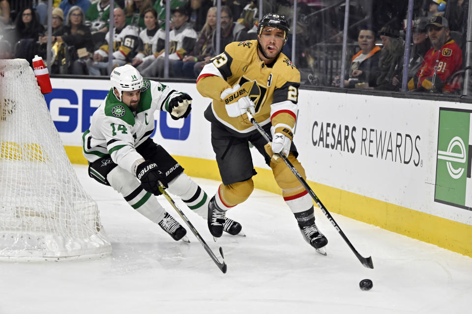 Vegas Golden Knights defenseman Alec Martinez (23) skates with the puck against Dallas Stars left wing Jamie Benn during the first period of an NHL hockey game Saturday, Feb. 25, 2023, in Las Vegas. (AP Photo/David Becker)