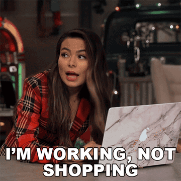 gif of Miranda Cosgrove is sitting with a laptop, dressed in a red plaid jacket. Text overlay reads, "I'M WORKING, NOT SHOPPING"
