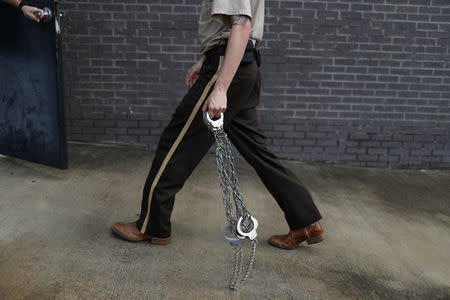 A member of the Zapata County Sheriff's Office carries shackles to put on undocumented immigrants following hearings at a U.S. federal court in McAllen, Texas, U.S., June 22, 2018. REUTERS/Loren Elliott