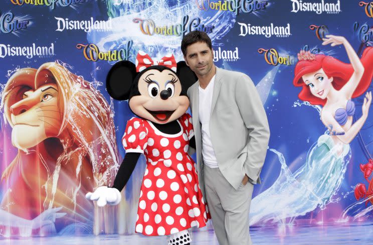 John Stamos poses with Minnie Mouse.