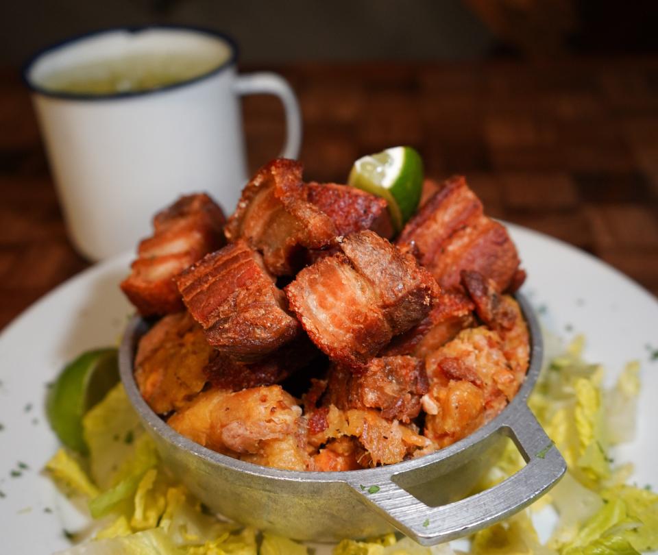 On the menu at Casa del Mofongo: smashed, chicharron-studded green plantains topped with fried pork chunks.