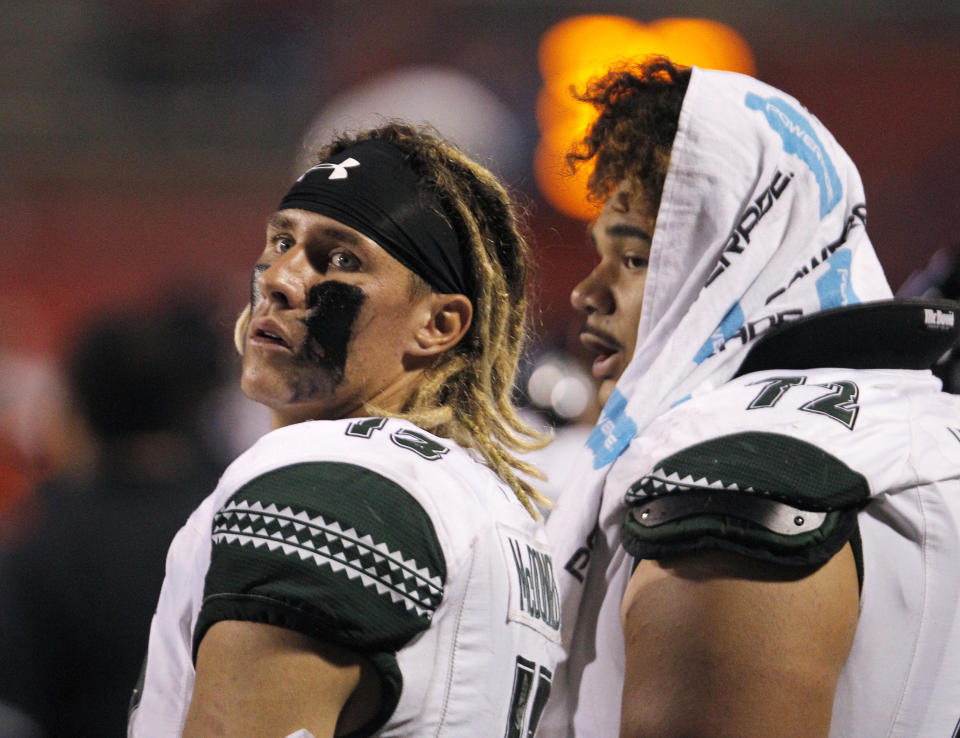 Hawaii quarterback Cole McDonald, left, checks the scoreboard in a blowout loss to Fresno State during the second half of an NCAA college football game in Fresno, Calif., Saturday, Oct. 27, 2018. Fresno State won 50-20. (AP Photo/Gary Kazanjian)