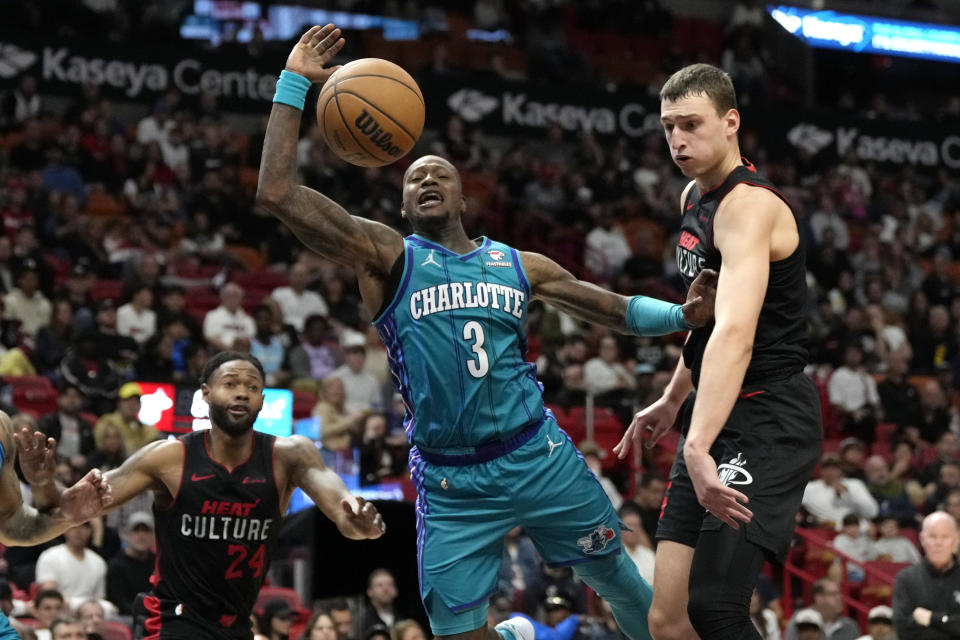 Charlotte Hornets guard Terry Rozier (3) loses control of the ball as Miami Heat forward Nikola Jovic, right, defends during the second half of an NBA basketball game, Sunday, Jan. 14, 2024, in Miami. (AP Photo/Lynne Sladky)