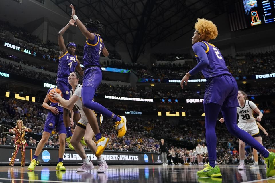 Iowa's McKenna Warnock is stopped by LSU's Sa'Myah Smith and Flau'jae Johnson during the first half of the NCAA Women's Final Four championship basketball game Sunday, April 2, 2023, in Dallas. (AP Photo/Darron Cummings)