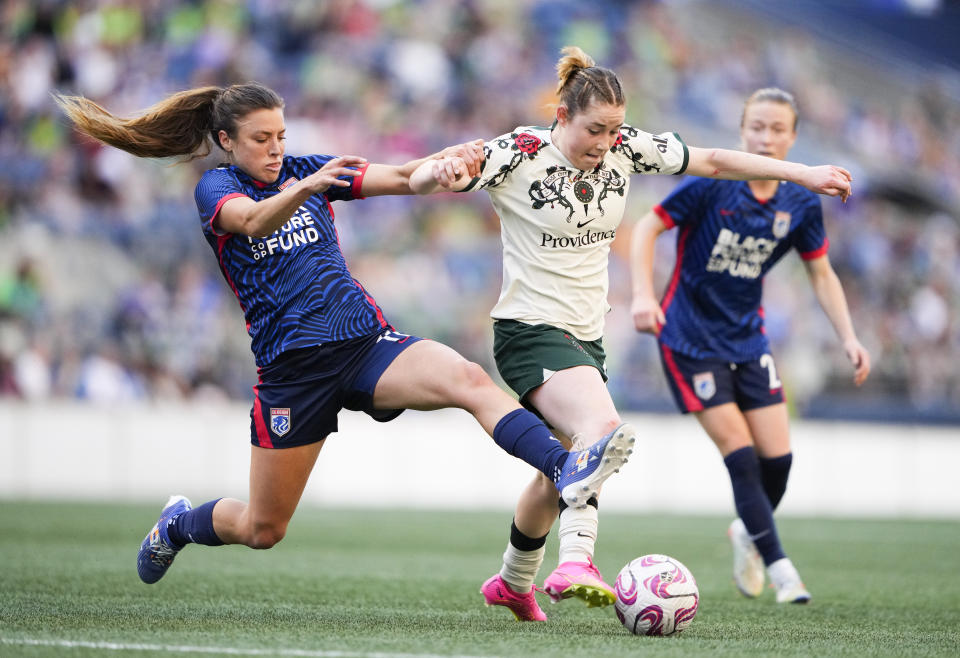 OL Reign defender Sofia Huerta, left, fouls Portland Thorns midfielder Olivia Moultrie, center, during the first half of an NWSL soccer match, Saturday, June 3, 2023, in Seattle. (AP Photo/Lindsey Wasson)