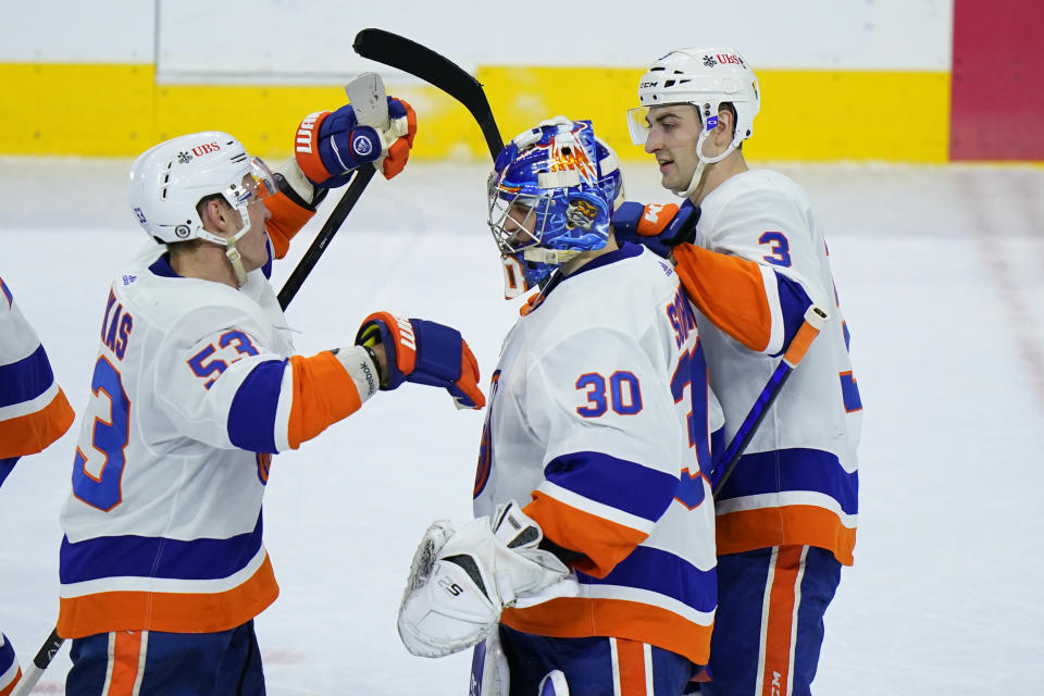 New York Islanders' Ilya Sorokin (30) celebrates with Casey Cizikas (53) and Adam Pelech (3) after the Islanders won an NHL hockey game against the Philadelphia Flyers in overtime, Sunday, April 18, 2021, in Philadelphia. (AP Photo/Matt Slocum)