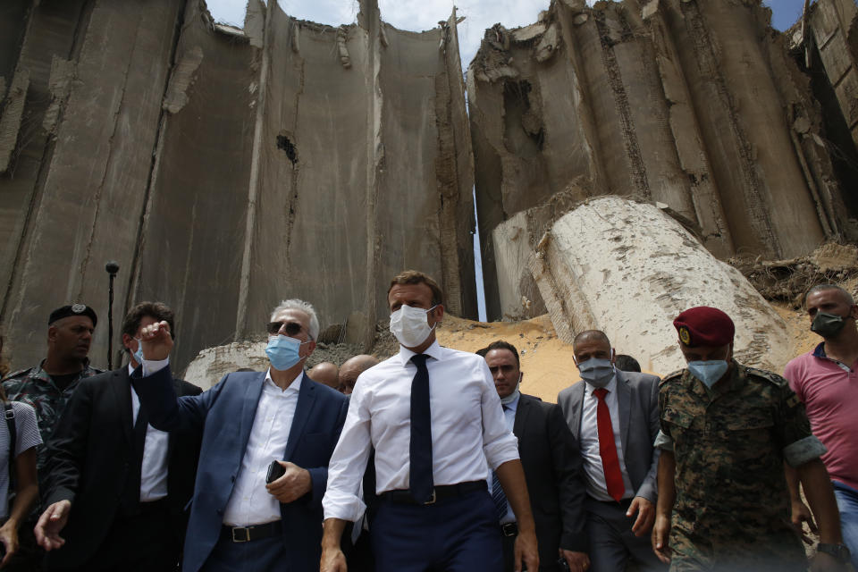 French President Emmanuel Macron, center, visits the devastated site of the explosion at the port of Beirut, Lebanon, Thursday Aug.6, 2020. French President Emmanuel Macron has arrived in Beirut to offer French support to Lebanon after the deadly port blast. (AP Photo/Thibault Camus, Pool)