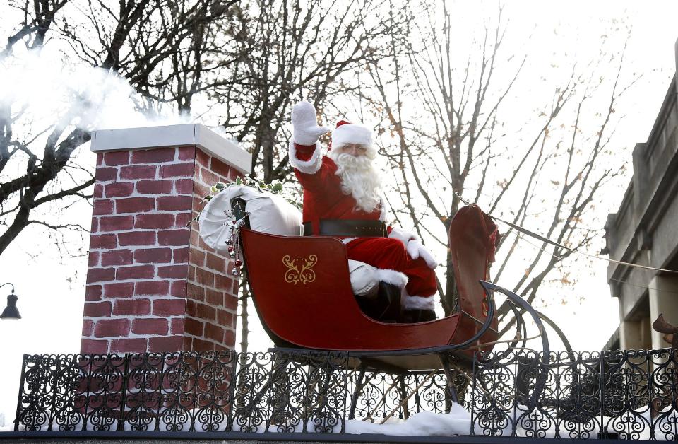 Santa waves to children during a past Downtown Elmira Holiday Parade.